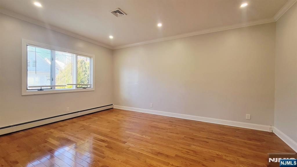164 Main Street, Unit 1 Garfield, NJ 07026 - Photo 3 of 14 a view of an empty room with wooden floor and a window