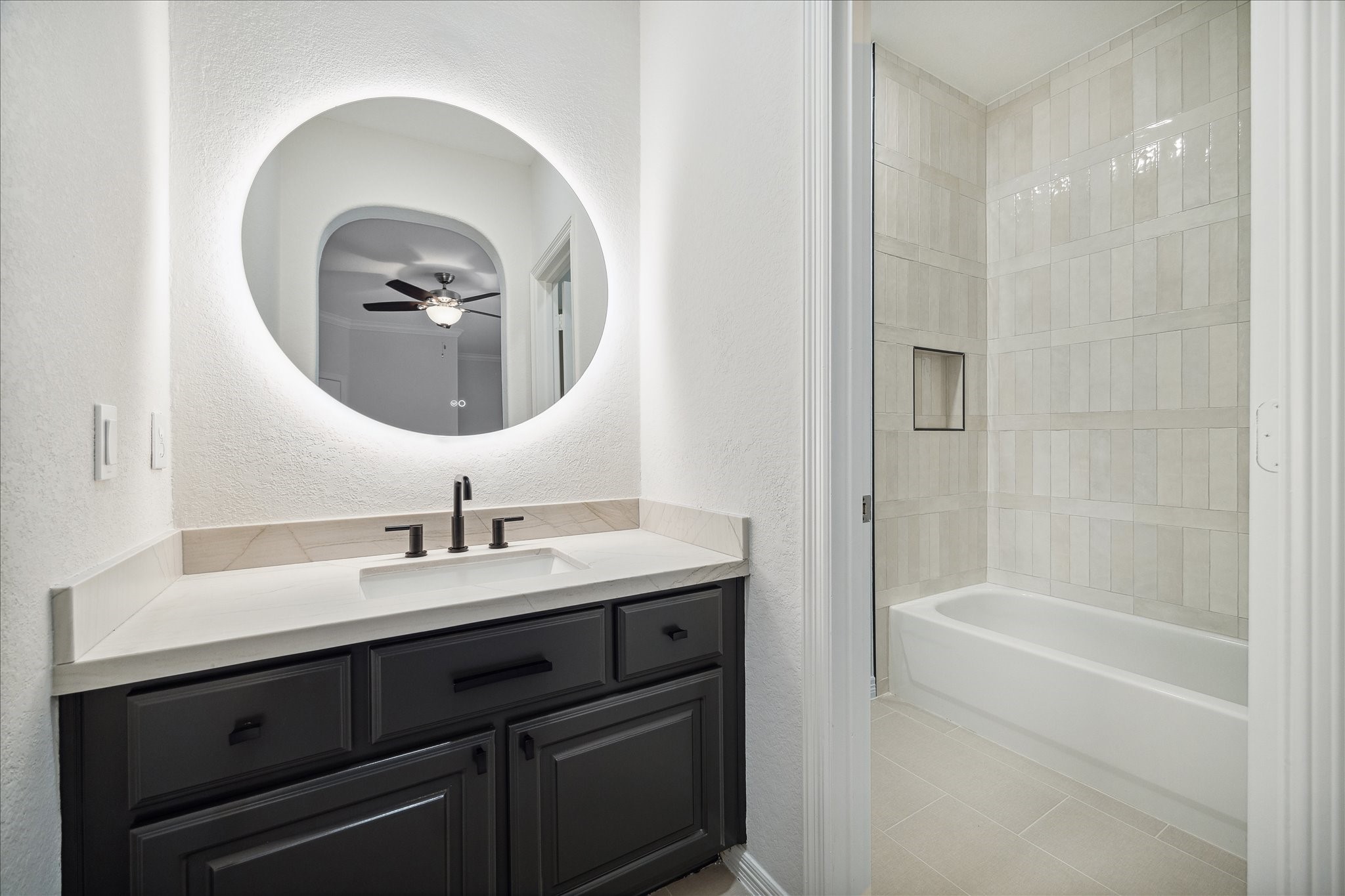 6211 Alameda Point Lane Houston, TX 77041 - Photo 40 of 50 Updated secondary bathroom with round backlit LED mirror, modern fixtures, and a tub/shower combo.