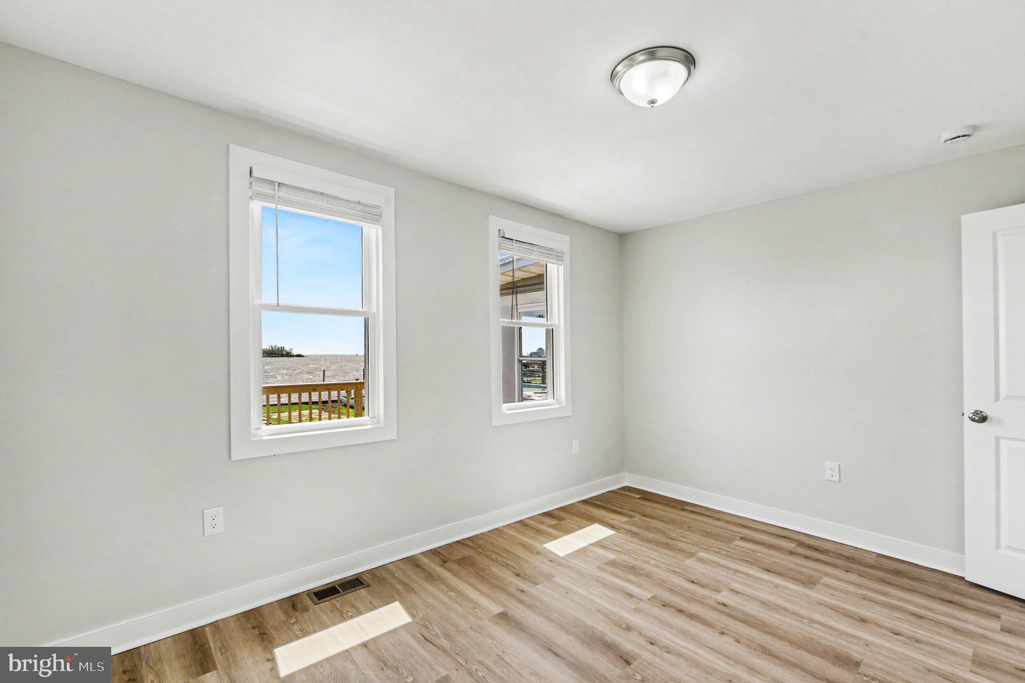 9135 Cuckold Point Road Sparrows Point, MD 21219 - Photo 15 of 44 an empty room with wooden floor and windows