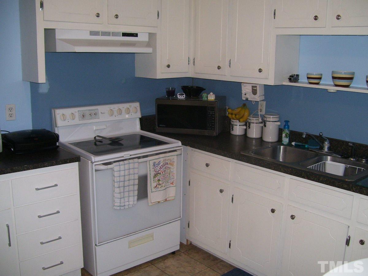 2153 Winkler Road Durham, NC 27712 - Photo 4 of 21 a kitchen with granite countertop white cabinets and white appliances