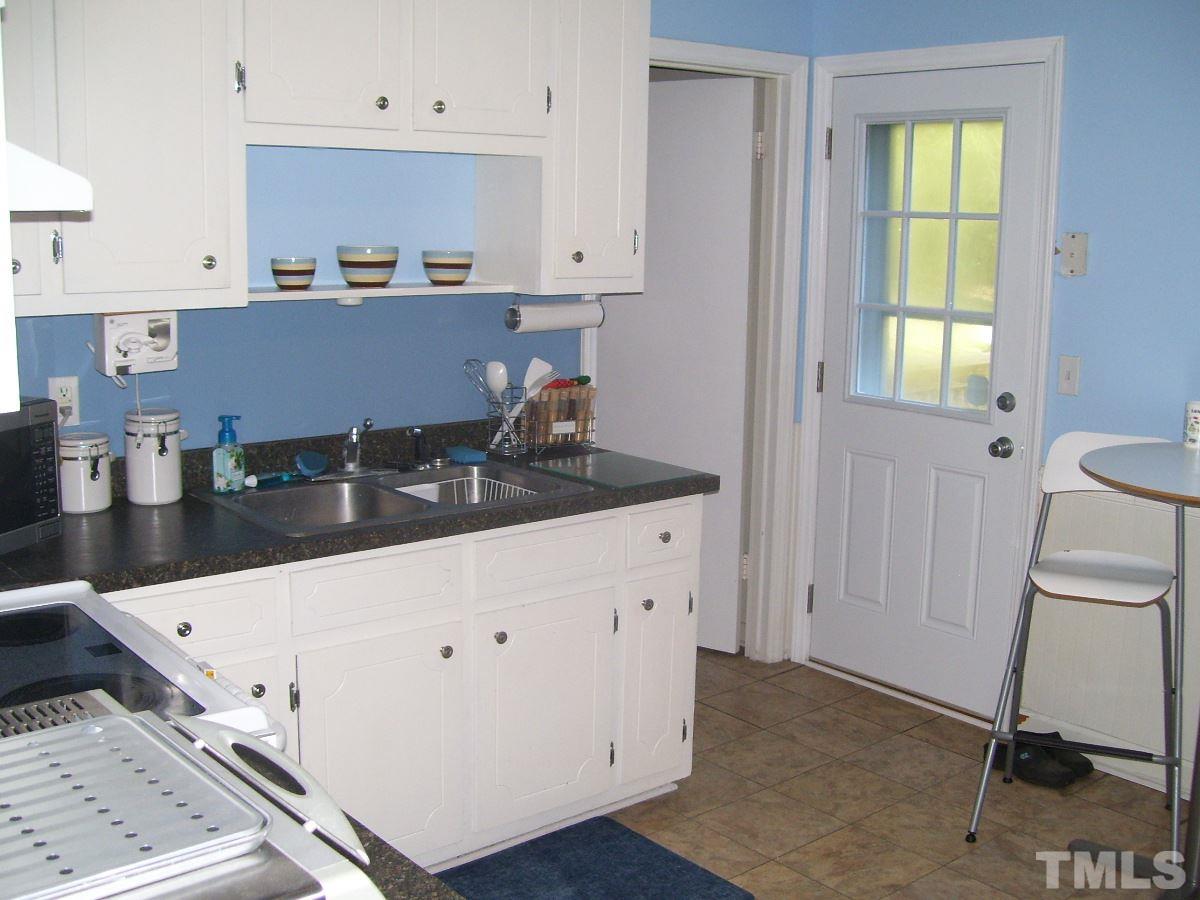 2153 Winkler Road Durham, NC 27712 - Photo 5 of 21 a kitchen with granite countertop white cabinets and window