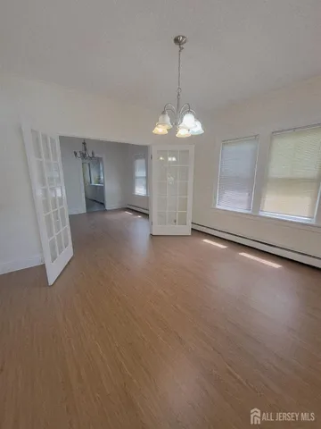 a view of a livingroom with a chandelier wooden floor and chandelier