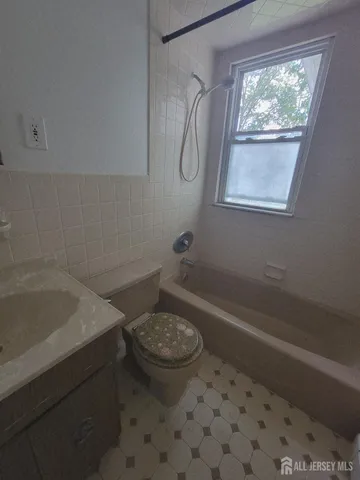 a bathroom with a granite countertop sink a toilet and a bathtub