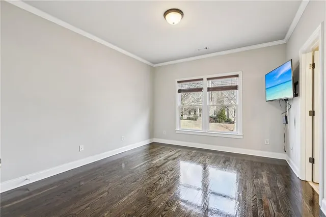a view of empty room with wooden floor