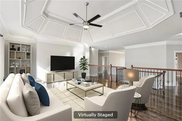 a living room with furniture a flat screen tv and a ceiling fan