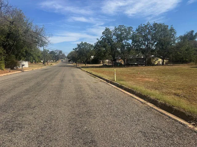 a view of a field with large trees