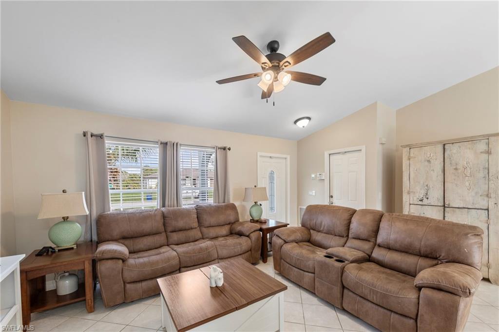 18435 Heather Road Fort Myers, FL 33967 - Photo 4 of 34 Vaulted ceiling living area featuring tile flooring, ceiling fan with integrated lighting, and multiple windows with blinds