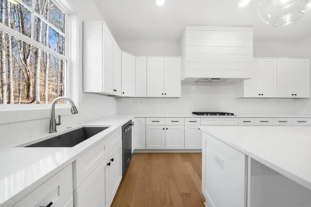 a large kitchen with kitchen island a stove a sink a center island and wooden floor