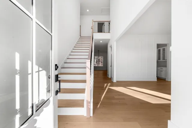 a view of a hallway with wooden floor and entryway