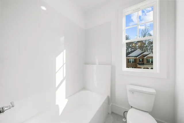 a view of a white house with a big yard and large trees