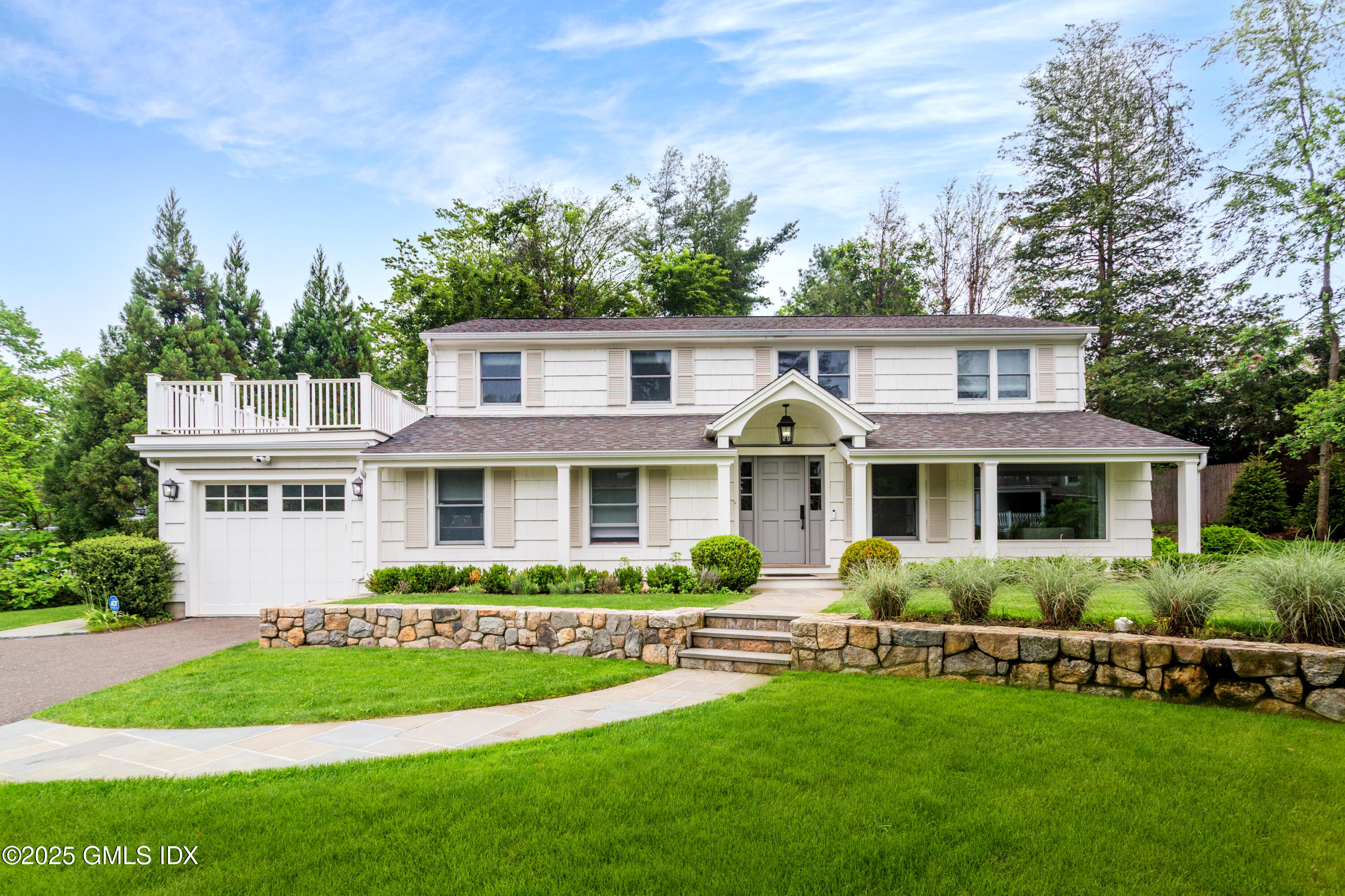 a front view of a house with a garden and plants