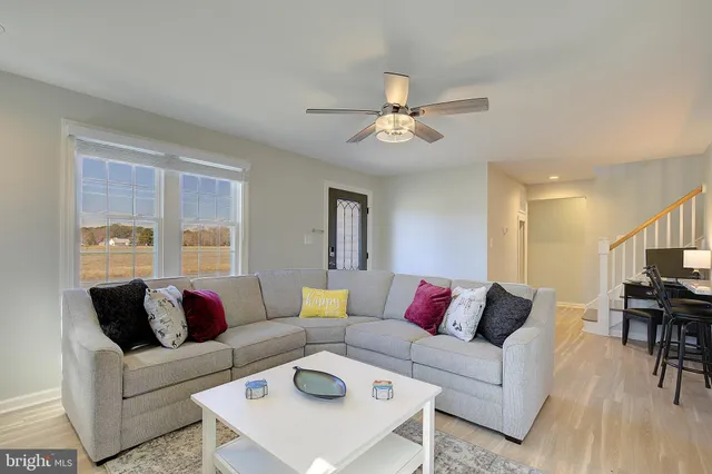 a living room with furniture and a flat screen tv with wooden floor