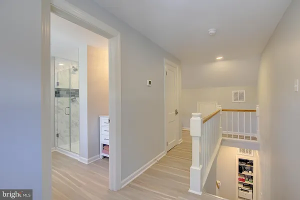 a view of a hallway with wooden floor and entryway