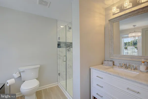 a bathroom with a granite countertop toilet a sink and a mirror