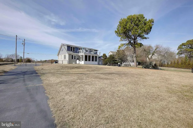 a front view of a house with a yard and trees