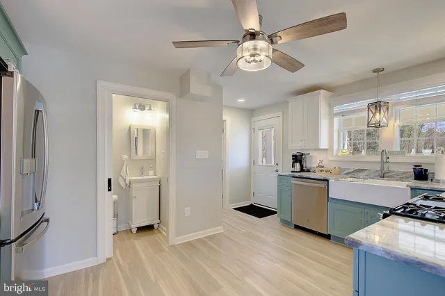 a view of a kitchen with a sink dishwasher stove and refrigerator with wooden floor