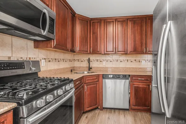 a kitchen with stainless steel appliances granite countertop a stove and a refrigerator
