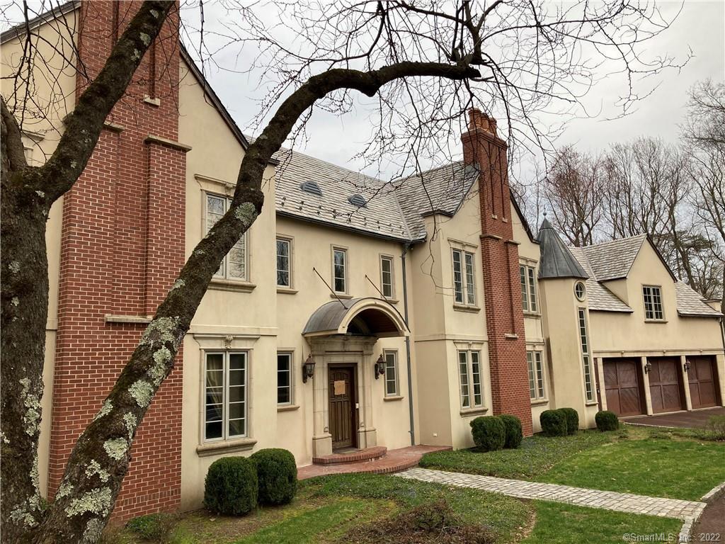 a front view of a house with yard and trees