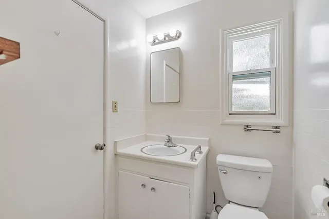a bathroom with a toilet a sink and mirror