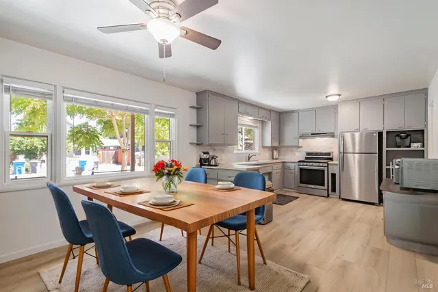 a kitchen with a dining table chairs and refrigerator