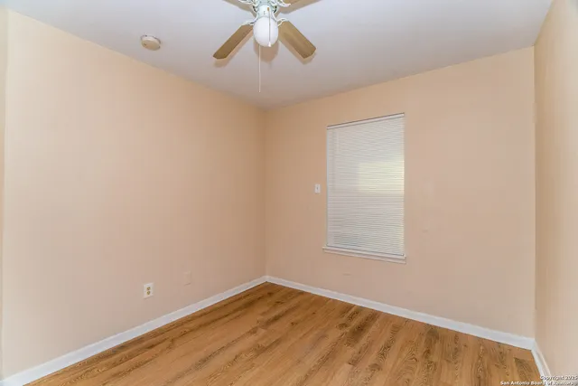 an empty room with a window and wooden floor