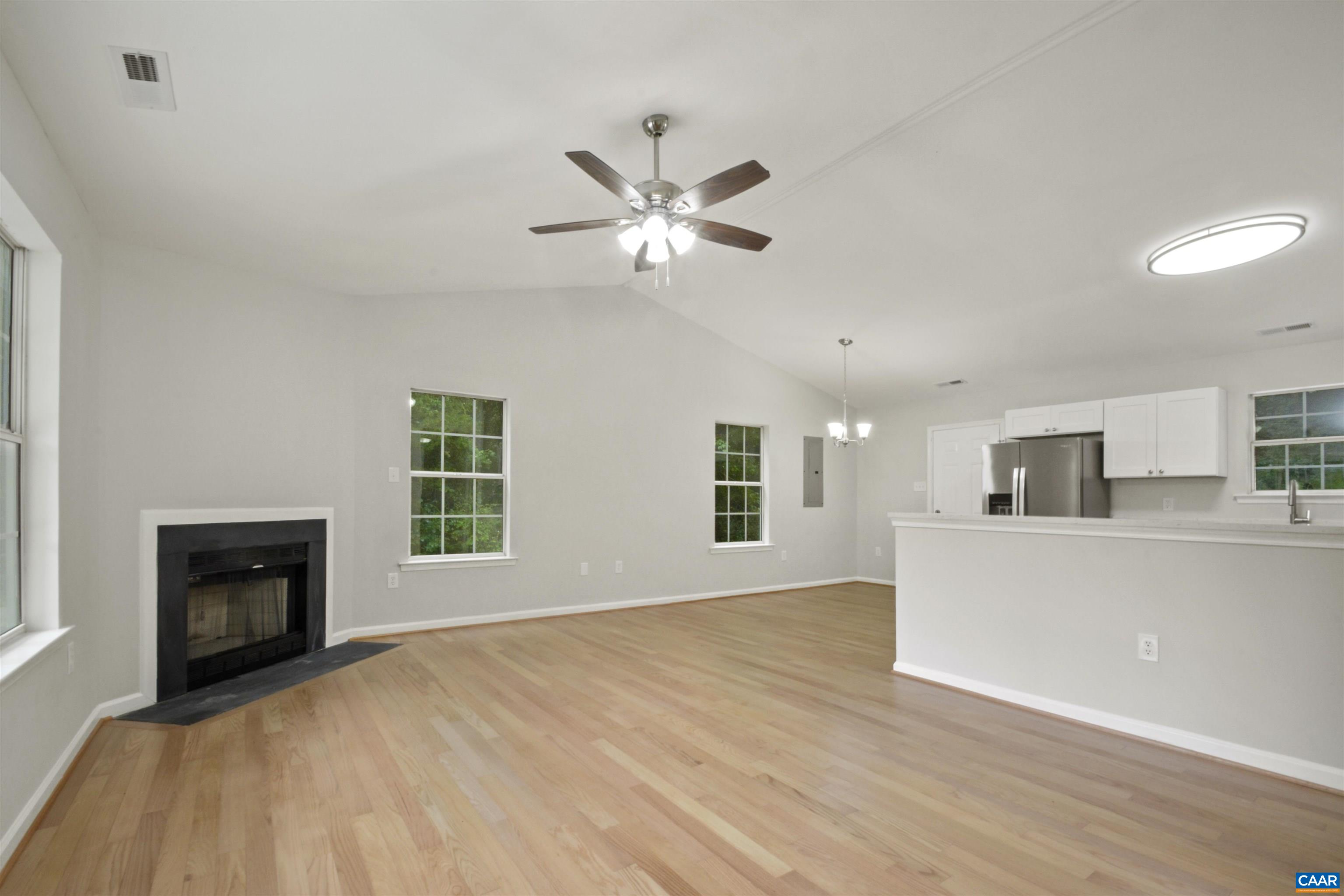263 Morning Glory Road Ruckersville, VA 22968 - Photo 10 of 24 a view of a livingroom with a fireplace a ceiling fan and wooden floor
