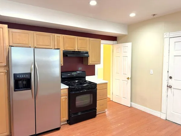a kitchen with stainless steel appliances granite countertop a refrigerator and a stove