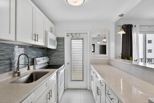 a kitchen with a sink stove top oven and refrigerator