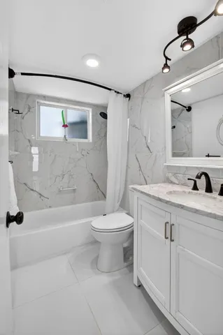 a bathroom with a granite countertop sink mirror and a toilet