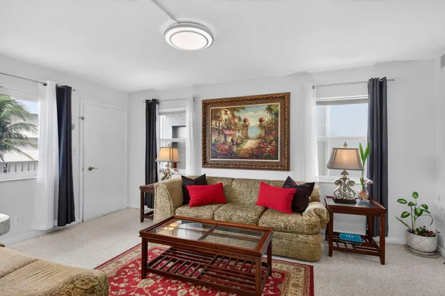 a living room with furniture and a dining table with kitchen view