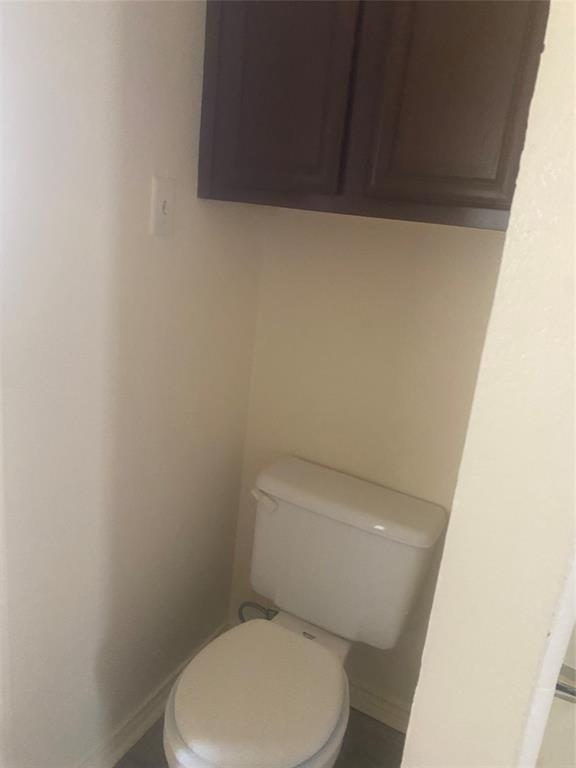 2809 Wimbledon Court, Unit C Garland, TX 75041 - Photo 17 of 23 a white toilet sitting next to a white cabinet