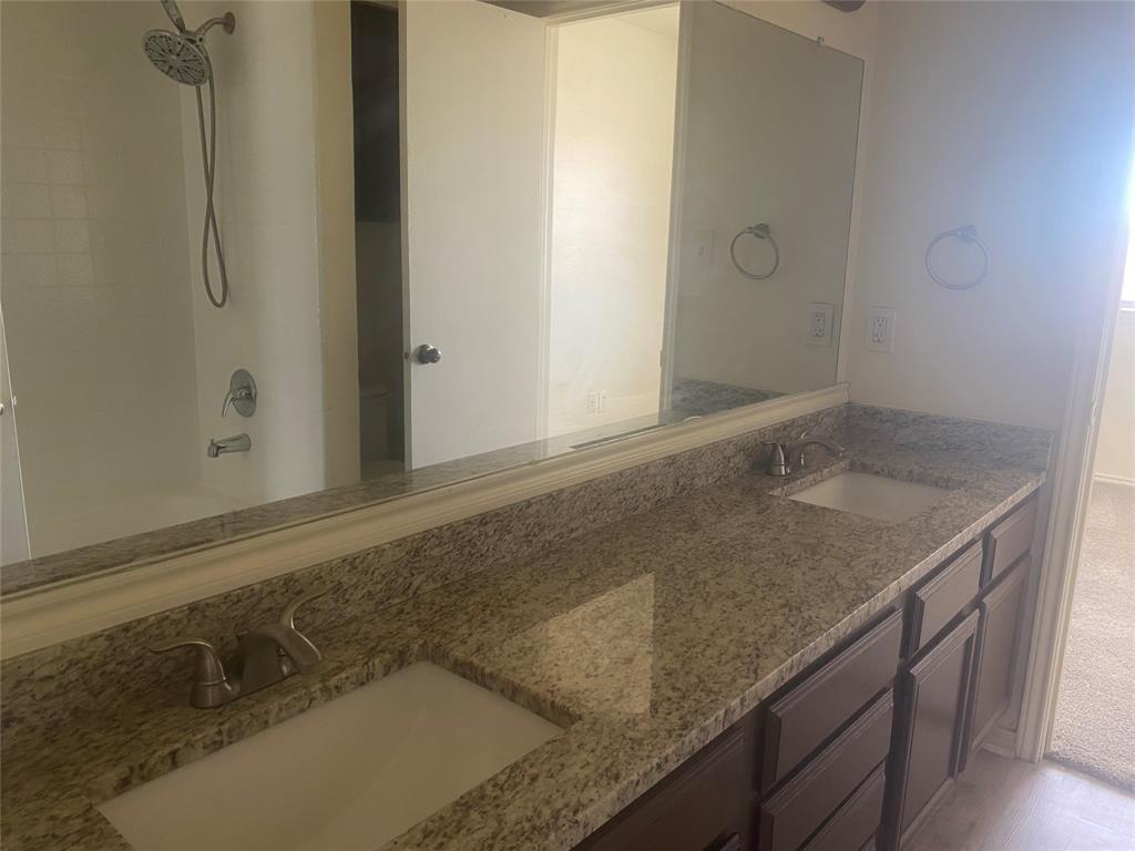 2809 Wimbledon Court, Unit C Garland, TX 75041 - Photo 20 of 23 a bathroom with a granite countertop sink and a mirror