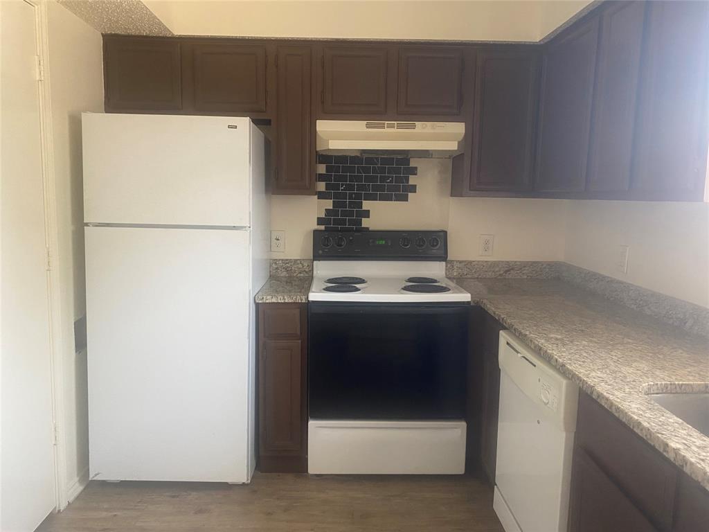 2809 Wimbledon Court, Unit C Garland, TX 75041 - Photo 6 of 23 a kitchen with a refrigerator and a stove