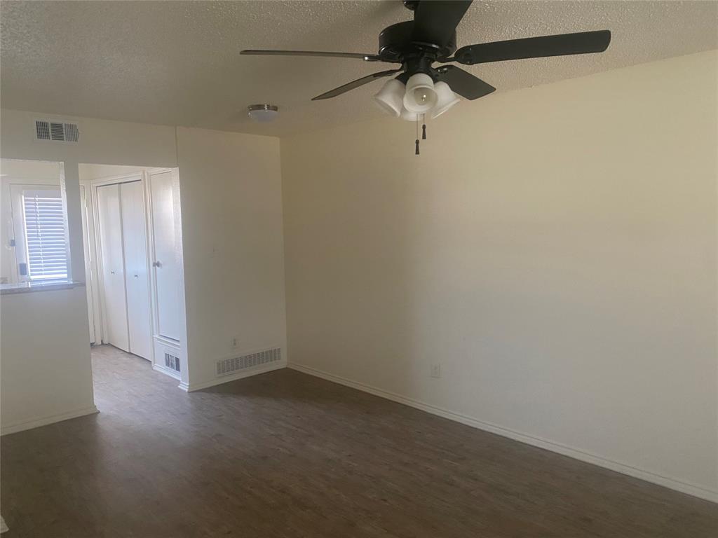 2809 Wimbledon Court, Unit C Garland, TX 75041 - Photo 7 of 23 an empty room with a ceiling fan and a window