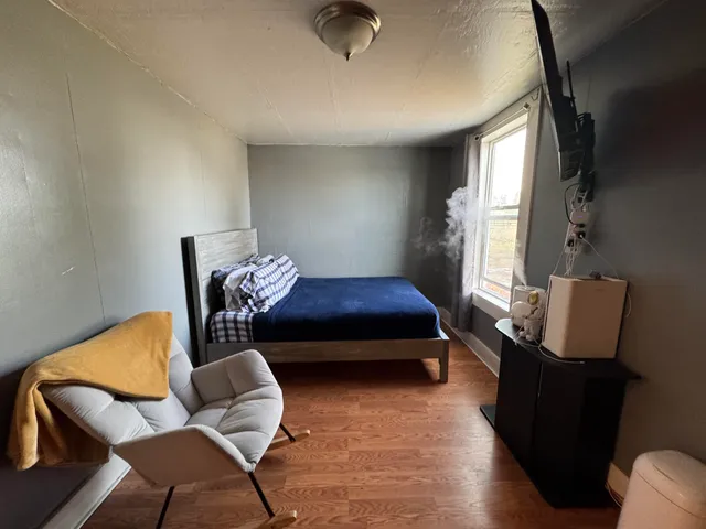 a bedroom with furniture and wooden floor