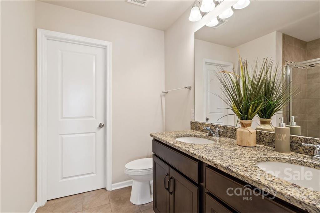 530 Hunters Dance Road Fort Mill, SC 29708 - Photo 27 of 35 a bathroom with a granite countertop sink a toilet and a mirror