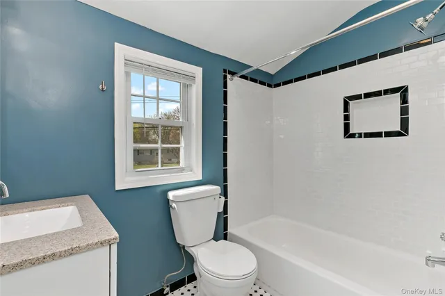 a white toilet sitting next to a bathroom sink and tub