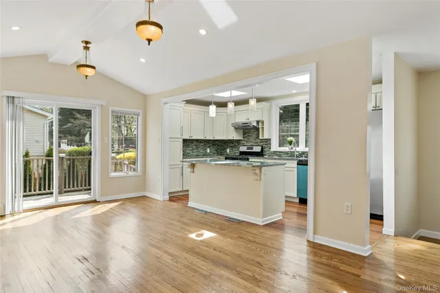 a view of a kitchen with wooden floor and windows