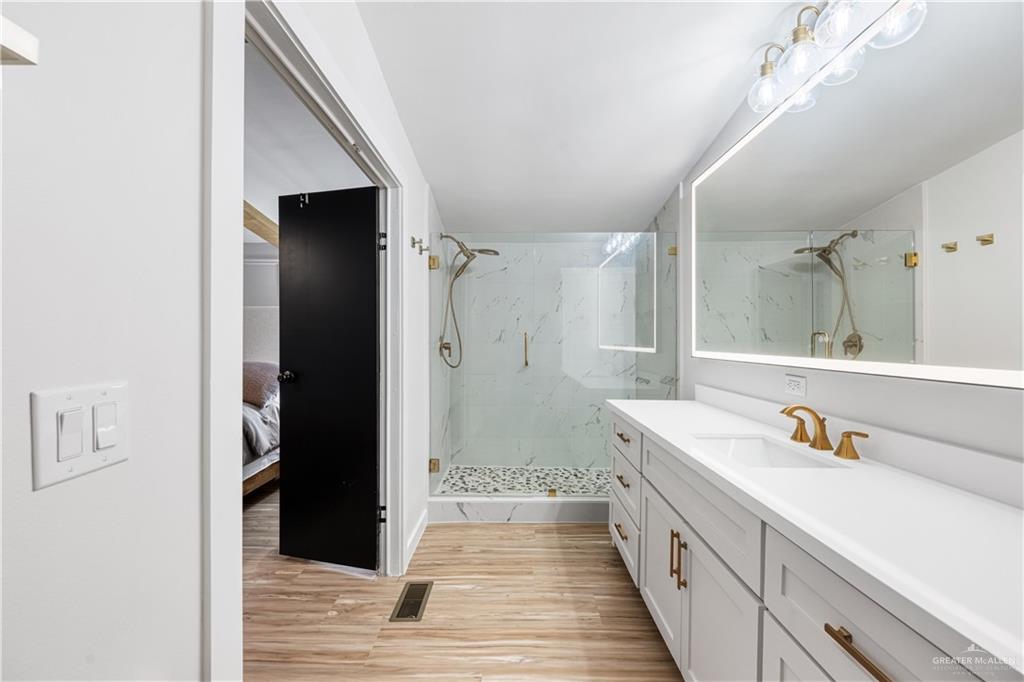 5501 Mile 8 1/2 Road Edinburg, TX 78541 - Photo 11 of 36 Bathroom featuring vanity, a marble finish shower, and light wood-style floors
