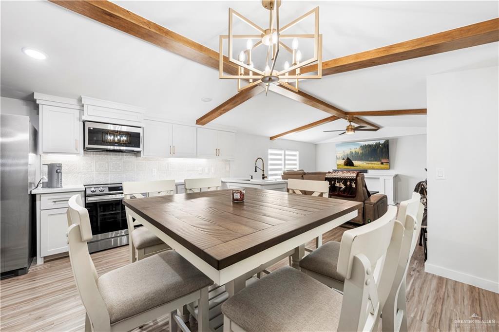 5501 Mile 8 1/2 Road Edinburg, TX 78541 - Photo 8 of 36 Dining room with hanging lights, light wood-type flooring, vaulted ceiling with beams, and ceiling fan
