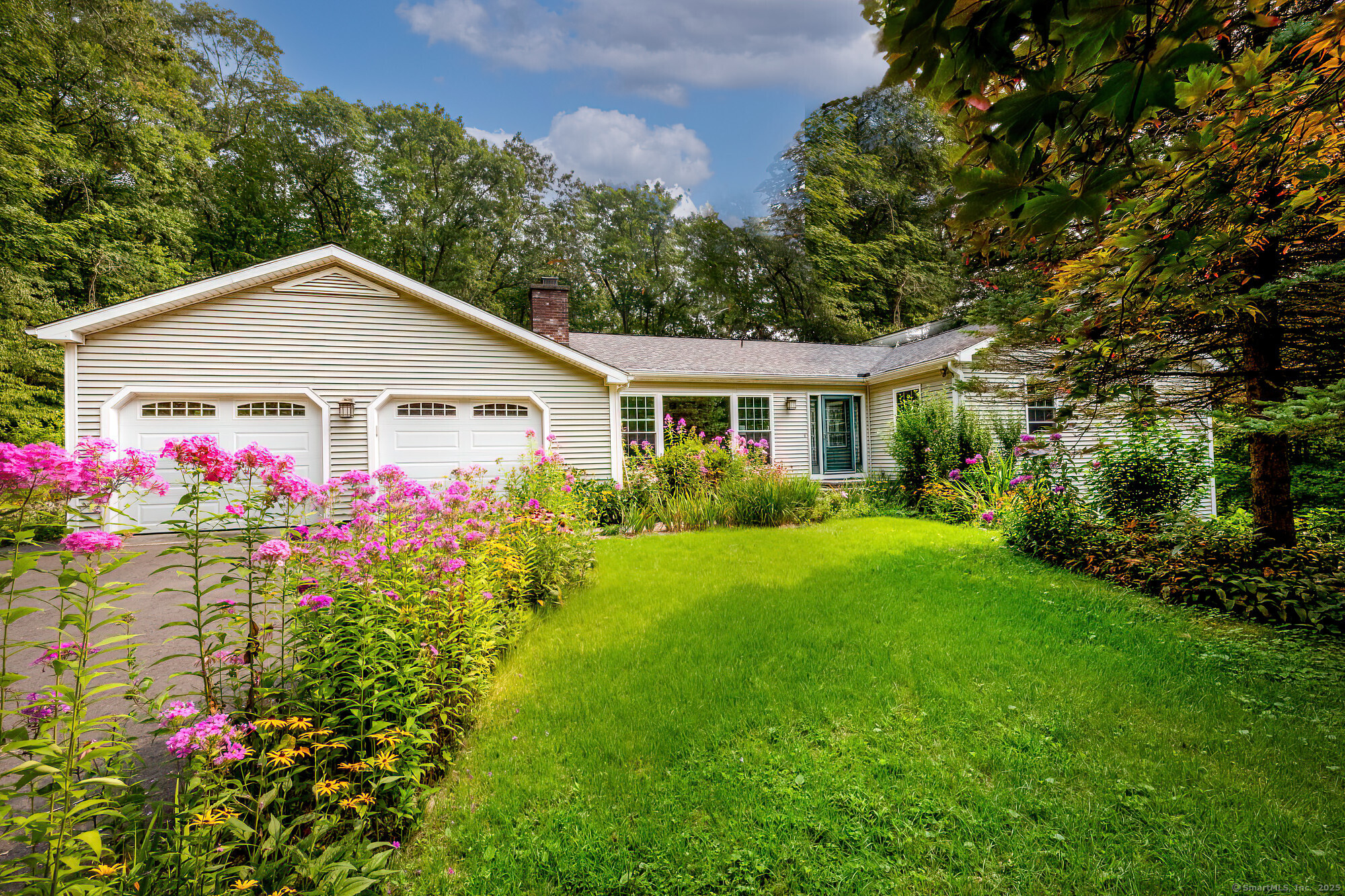 a front view of a house with a big yard and potted plants