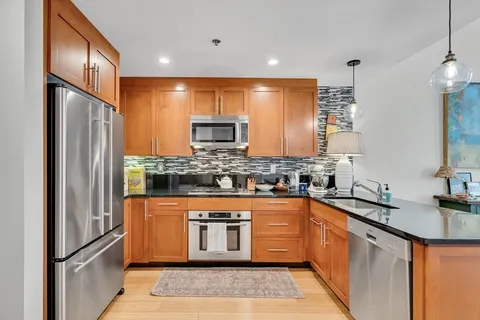 a kitchen with stainless steel appliances granite countertop a stove a sink and a microwave