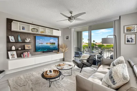 a living room with furniture a flat screen tv and a large window