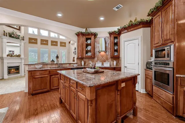 a kitchen with stainless steel appliances granite countertop a stove a sink and a refrigerator