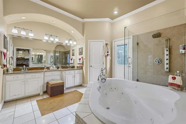 a spacious bathroom with a tub sink and glass door