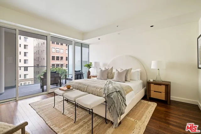 a spacious bedroom with a bed a table and a large window