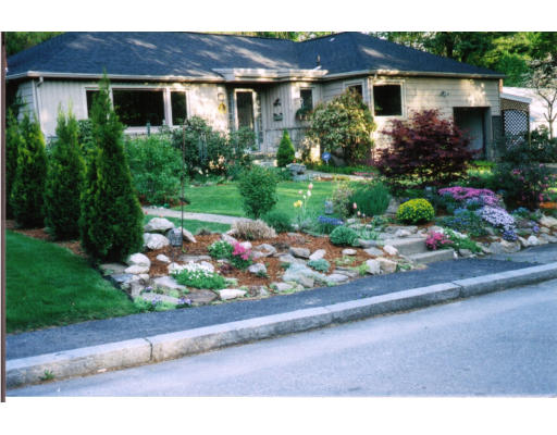 a front view of a house with a yard and a garden