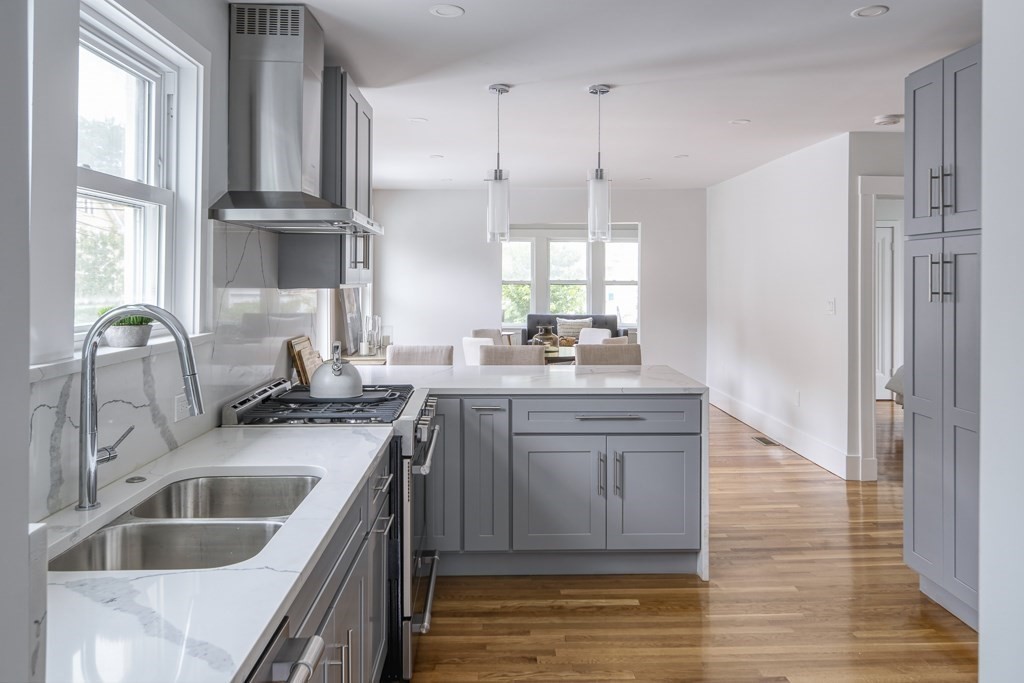 1 Mary Street, Unit 1 Arlington, MA 02474 - Photo 12 of 27 a kitchen with kitchen island white cabinets a sink a window and stainless steel appliances