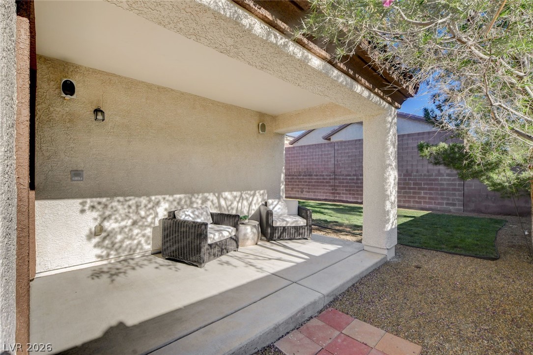 2649 Rue Marquette Avenue Henderson, NV 89044 - Photo 50 of 55 Enjoy outdoor relaxation on this sheltered patio, offering ample space for comfortable seating and serene backyard views.