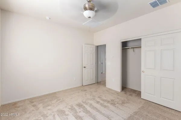 a view of an empty room with a ceiling fan